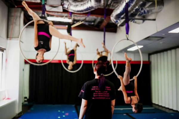 Colour photo showing four students in the air while being instructed